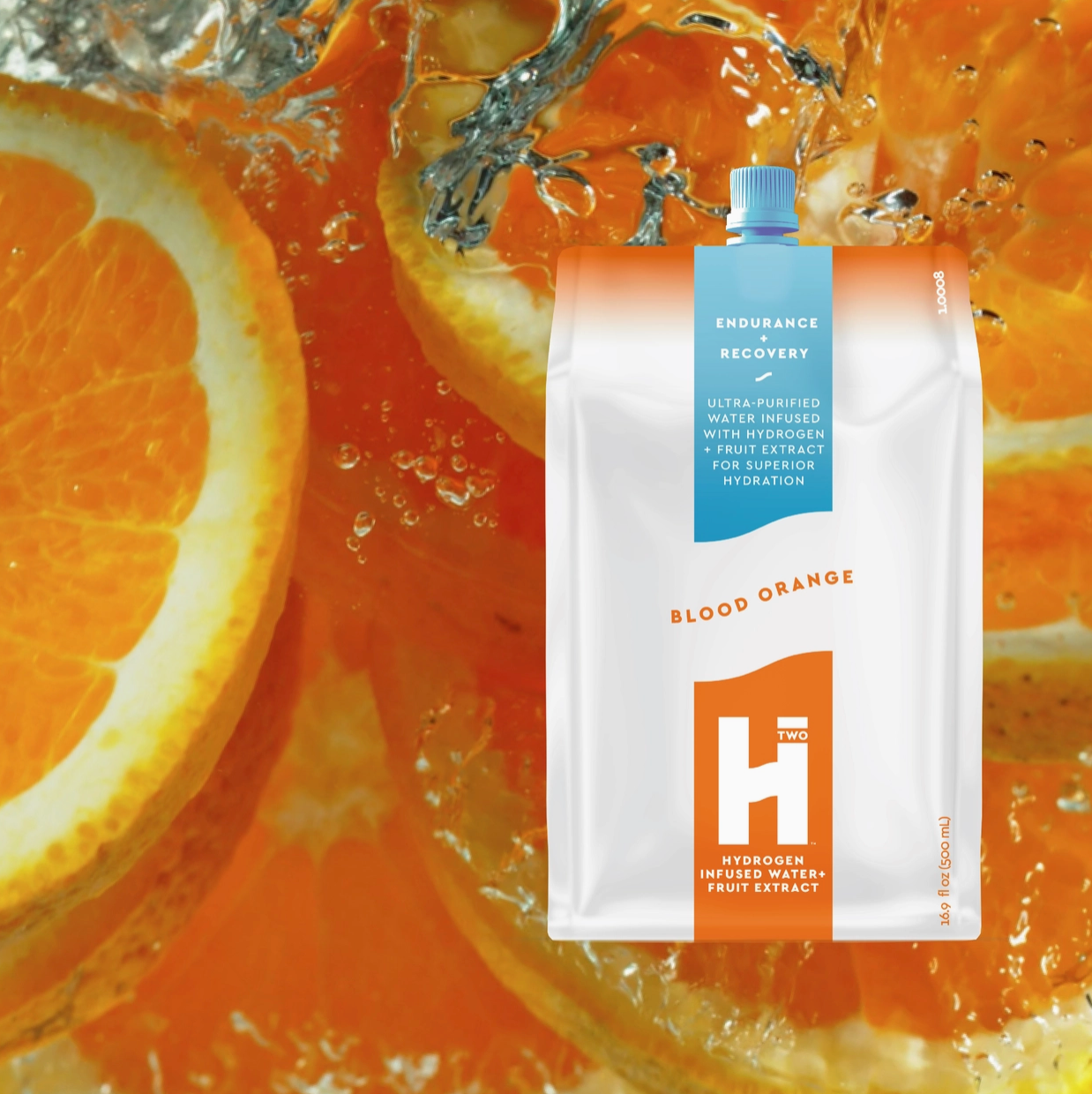 Hydrogen fruit extract package with blood orange flavor surrounded by sliced oranges and water droplets.